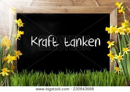 Blackboard With German Text Kraft Tanken Means Relax. Sunny Spring Flowers Nacissus Or Daffodil With