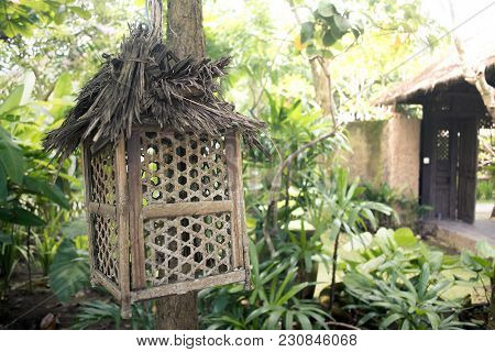 Ornamental Bamboo Lamp Post On Garden. Empty Wooden Bird Cage