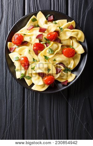 Italian Dumplings Casoncelli Stuffed With Ham With Cherry Tomatoes Close-up On A Plate. Vertical Top