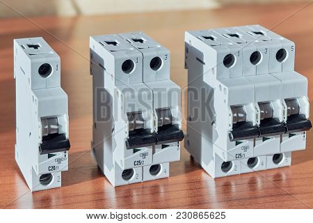 Three Modular Electrical Circuit Breakers On The Table. The Switch Is Single-pole, Double-pole And T