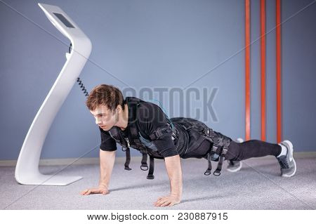 Man In Electrical Muscular Stimulation Suits Doing Plank Exercise. Ems. Workout.