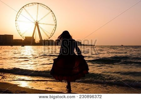 Girl On The Jbr Beach With Ain Dubai Ferris Wheel At Sunset