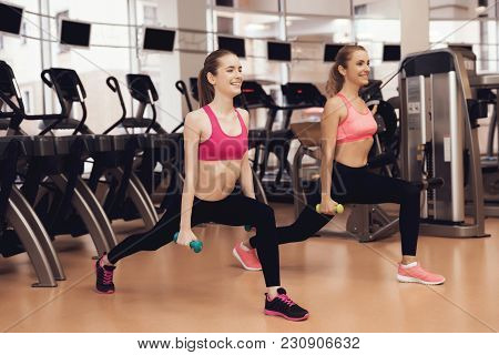 Mother And Daughter In Sportswear Doing Exercises With Dumbbells At The Gym. They Look Happy, Fashio