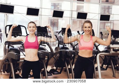 Mother And Daughter In Sportswear Doing Exercises At The Gym. They Look Happy, Fashionable And Fit.