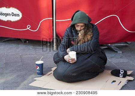 London, England - July 12, 2016 A Beggar Asleep And Holding A Dog In His Arms