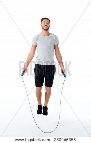 Attractive Sportsman With Jumping Rope Exercising Isolated On White