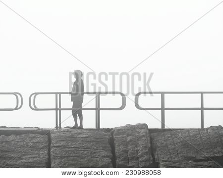 Woman Standing On Jetty On A Foggy Day