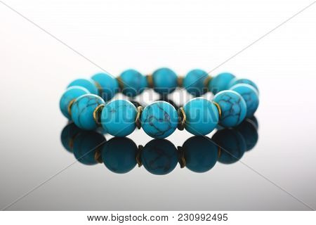 Bracelet Of Bijouterie Jewelry Made Of Turquoise And Gold On A Gray Black Background