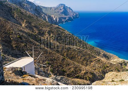 Old Mill On A Hill On A Greek Island With Sea In Background