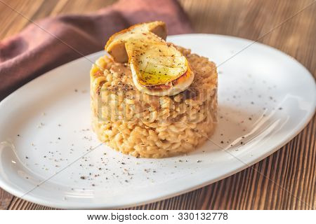 Risotto With Porcini Mushrooms On The White Plate