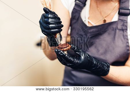 Pastry Chef Squeezes Chocolate Cream From A Pastry Bag Onto Cookies. Making Chocolate Cookie Sandwic