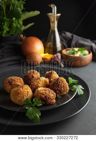 Homemade Croquettes On Dark Wooden Background, Ingredients For Its Elaboration In The Background
