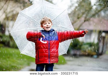 Beautiful Little Kid Boy On Way To School Walking During Sleet, Rain And Snow With An Umbrella On Co