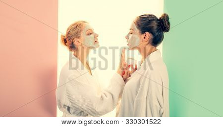 Young Beautiful Blonde Women Applies Clay Mud Mask At Face Of Her Friend. Organic Natural Cosmetic F