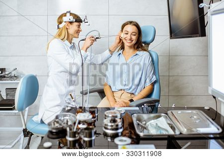 Senior Otolaryngologist Making Endoscopic Examination Of An Ear For A Young Patient At The Ent Offic