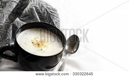 Cauliflower Soup (creme Du Barry) In Black Bowl On White Background With Black And White Cloth With 