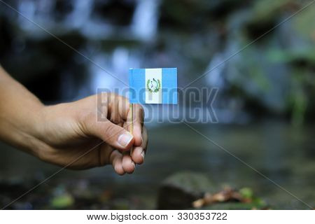 Blue And White National Flag Of Guatemala In Person Hand. Colour Man Holds Flag On Wooden Stick And 