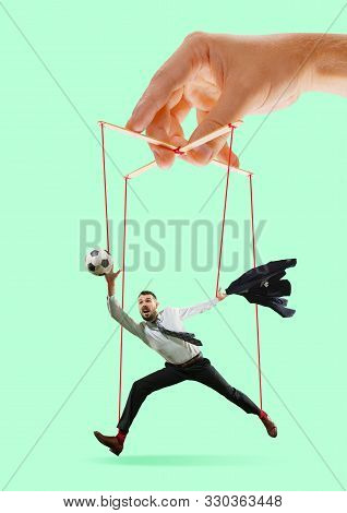 Man Like A Puppet In Somebodies Hands On Green Background. Concept Of Unfair Manipulation, Phycology
