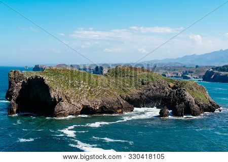 Scenic View Of Sea Against Blue Sky In Rocky Coast