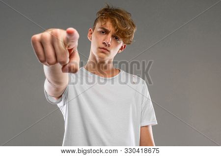 Handsome Emotional Teenager Boy Posing In Studio Against Gray, Prankster Concept
