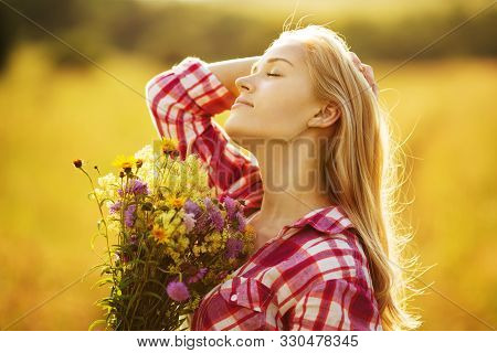 Happy Beautiful Girl With A Bouquet Of Wild Flowers