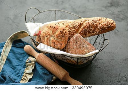 Bread in a basket on a black background. Assorted baking in a metal basket. Place for recipe and tex