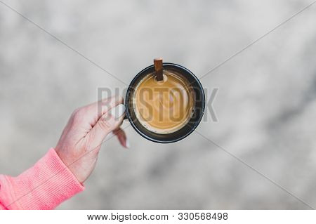 Woman's Hand Holding Coffee Cup With Latte From Topdown Perspective