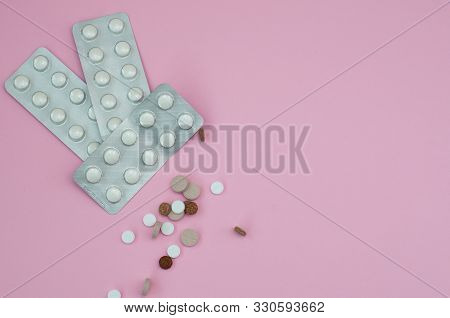 Assorted Pharmaceutical Medicine Pills, Tablets And Capsules On Pink Background. Top View. Flat Lay.