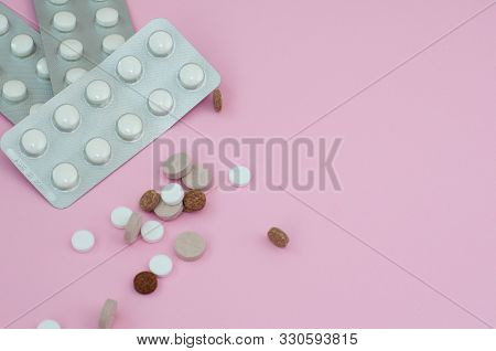 Assorted Pharmaceutical Medicine Pills, Tablets And Capsules On Pink Background. Top View. Flat Lay.