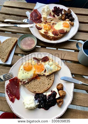 Turkish Breakfast With Fried Eggs, Sucuk, Pastirma / Pastrami, Honey, Cheese And Bread Slices.