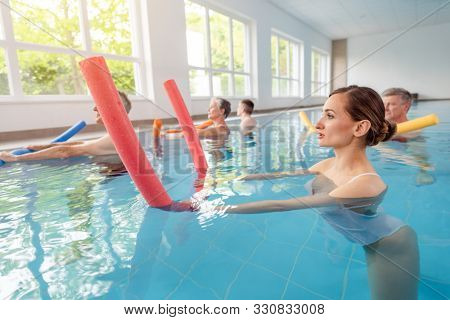 Patients during remobilization in a health center doing aquarobics in the water of a pool