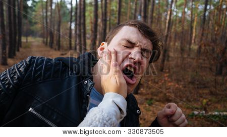 A Womans Hand Hits A Mans Face In The Autumn Forest. An Emotional Male Is Getting Slapped In Face, W
