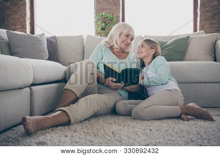 Photo Of Two People Aged Granny Little Granddaughter Sitting Floor Near Sofa Reading Together Girl C