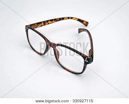 Reading Glasses In A Classic Tortoise Shell Pattern Is Isolated In A Light Background.