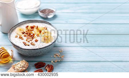 Overnight Oats With Banana And Pecans, Chia Seeds In Bowl With Ingredients Around. Healthy High Prot