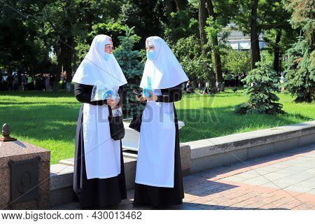 Nuns In Church Robes Hand Out Medical Masks On A Kiev Street. Religious Women, Parishioners Of The O