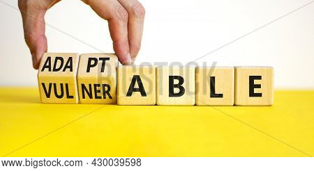 Vulnerable Or Adaptable Symbol. Businessman Turns Wooden Cubes And Changes The Word Vulnerable To Ad
