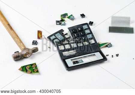 Hammer And Broken Into Pieces Calculator On White Background. Buttons, Body Pieces, Board, Display, 