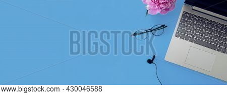Workspace Of A Writing Desk With A Copy Space.computer, Microphone, Glasses For Work On A Blue Backg