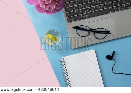 The Concept Of Education, Training, Online Courses. Laptop, Glasses, Notepad, Microphone On A Pink A