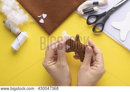 Filling The Felt Christmas Gingerbread Man With Holofiber. Step-by-step Manufacturing Instructions. 