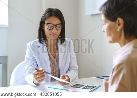 Pleasant African Female Doctor In White Coat Explaining Prescription And Treatment To Middle-aged Wo