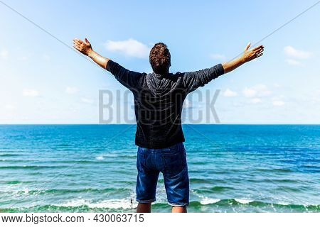 Caucasian Man Spreading Arms And Watching The Ocean. Happy Man With Outstretched Arms.man With His A