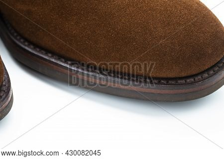 Extreme Closeup Of Texture Of Toes Of Brown Suede Mens Shoes Over White Background.