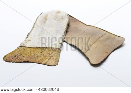 Texture Closeup Of Pair Of Brown Used Removable Shoe Insoles Placed Over White Background.