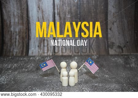 'malaysia National Day' Word With Wooden Dolls Holding Malaysia Mini Flag.