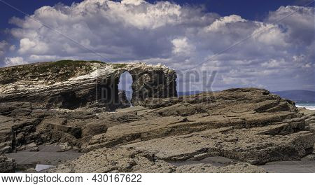 View Of Playa De Las Catedrales In Ribadeo, Galicia, With The Sea In The Background And Cloudy Sky.