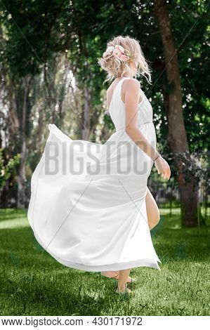 Bride Or Fiancee. Rear Back View. Happy Woman Wearing Long Whire Wedding Dress Dancing In Summer Par