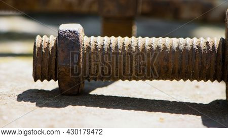 Old Rusty Bolt, Iron Rod With Screw Threads. Rusted Mechanical Components. Threaded Bolt And Nut. Di