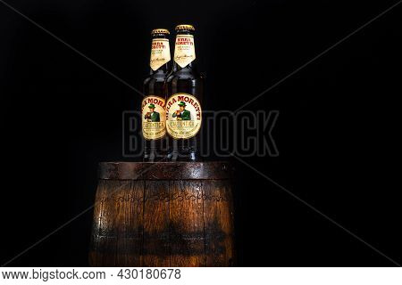 Bottle Of Birra Moretti Beer On Wooden Barrel With Dark Background. Illustrative Editorial Photo Buc